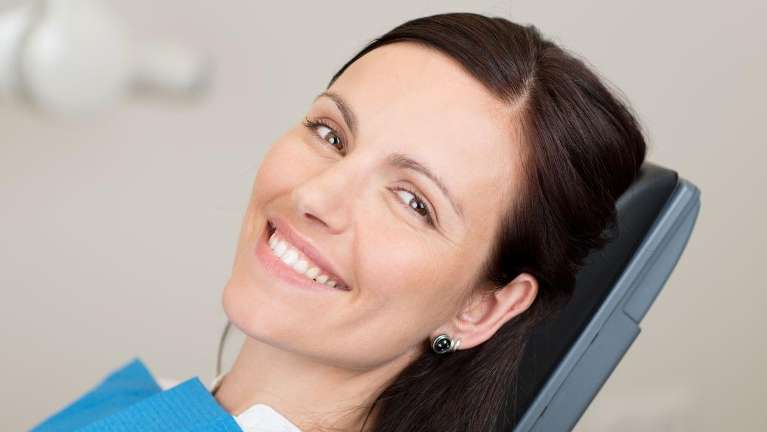 woman sitting in a dental chair | Dentist Evansville, IN